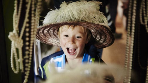 Child dressing up in period costume and looking in a mirror at Lyme Park, Cheshire